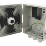 Ein geöffneter grauer Verteilerkasten mit Löchern für Kabeldurchführungen und Befestigungsmöglichkeit an der Innenseite.