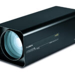 Ein rechteckiges Objektivgehäuse mit einer großen Linse vorne und Schriftzügen an der Seite von "Fujinon", das wahrscheinlich für optische Zoomanwendungen eingesetzt wird.