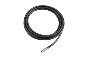 Schwarzes Kabel mit einem metallischen Stecker am Ende, aufgerollt.