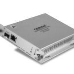 Ein silbernes Kommunikationsgerät von Comnet, das Netzwerkanschlüsse auf der Vorderseite zeigt.