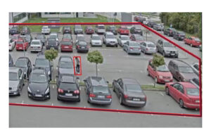Ein Parkplatz mit mehreren Autos und einem eingekreisten Bereich, der einen Mann zeigt, der sich in der Nähe eines Autos befindet.