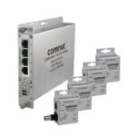 Ein Netzwerkgerät von ComNet mit vier Ethernet-Ports, neben fünf kleineren Verpackungseinheiten der Marke.