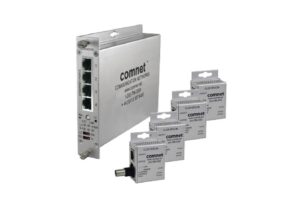 Ein Netzwerkgerät von ComNet mit vier Ethernet-Ports, neben fünf kleineren Verpackungseinheiten der Marke.