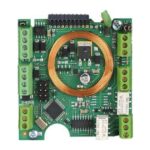 Elektronische Leiterplatte mit einer kupferfarbenen spiralförmigen Wicklung in der Mitte und mehreren grünen Steckverbindungen an den Rändern.