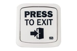 Eine weiße Wandplatte mit der Aufschrift "PRESS TO EXIT" und einem Pfeilsymbol, das auf eine Tür zeigt.