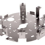 Eine metallische Halterung mit verschiedenen Öffnungen und Halterungen in einer kreisförmigen Anordnung.