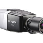 Eine Bosch Dinion Überwachungskamera in seitlicher Ansicht mit silbernem und schwarzem Gehäuse sowie einem großen Objektiv.