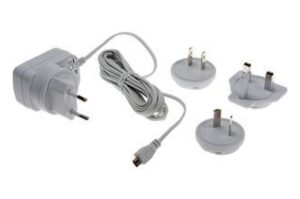 Ein weißes Netzteil mit Kabel und vier austauschbaren Steckern für verschiedene Steckdosenstandards.