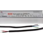 Ein rechteckiges elektronisches Gerät mit der Aufschrift "HLG-240H-24" und mehreren Zertifizierungssymbolen. Zwei Kabelstränge ragen heraus.