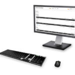 Ein Computermonitor mit einer Software-Oberfläche, daneben eine Tastatur und eine Maus.