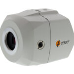 Eine weiße, rechteckige Überwachungskamera der Marke Eneo mit einer Linse auf der Vorderseite.