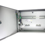 Ein offener, leerer Metallkasten mit einer Tür an der linken Seite, die mit einem Schloss gesichert ist. Im Inneren sind Drähte, Anschlüsse und Montageelemente sichtbar.