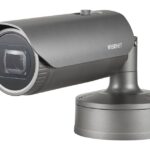 Eine graue Wisenet-Überwachungskamera auf einem Ständer.