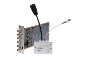 Ein elektronisches Gerät mit mehreren Koaxialanschlüssen und einem Kabel, das an ein weißes Modul angeschlossen ist.
