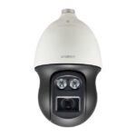 Eine Überwachungskamera der Marke Wisenet, mit einem weißen Gehäuse und Objektiven in der unteren, schwarzen Hälfte, frontal fotografiert.