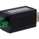 Schwarzes elektronisches Gerät mit grüner Steckverbindung und silbernem Anschluss.