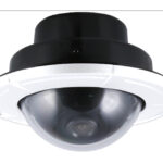 Eine Überwachungskamera mit einer halbkugelförmigen Linse und einem schwarzen Gehäuse, montiert auf einer weißen Halterung.