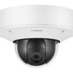 Überwachungskamera in weißem Gehäuse mit sichtbarer Linse und WISENET-Logo.