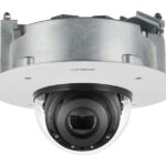 Eine runde, weiße Überwachungskamera mit einer transparenten Kuppelabdeckung und hervorstehendem Objektiv.