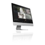 Ein Computermonitor zeigt ein Überwachungssystem mit vier Live-Kameras in einem städtischen Umfeld.