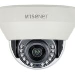 Überwachungskamera mit der Aufschrift "WISENET", montiert in einer weißen Gehäusefassung.