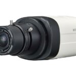 Eine weiße Überwachungskamera mit schwarzem Objektiv und der Aufschrift "Wisenet".