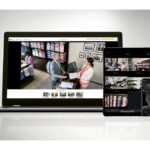 Ein Laptop, Tablet und Smartphone mit Sicherheitskamera-Überwachungsbildern eines Bekleidungsgeschäfts.