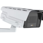 Eine weiße Überwachungskamera mit montiertem Schutzgehäuse an einer Wandhalterung.