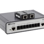 Ein PoLRE LPC Unmanaged Switch von Phybridge mit mehreren Ethernet-Anschlüssen und zwei zusätzlichen Geräten oben.