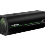 Kompaktes Objektiv "Fujinon" von Fujifilm, schwarzes Gehäuse mit grüner Linie und Beschriftung zur Bildstabilisierung und schnellem Autofokus.