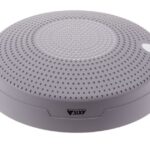 Eine graue, runde elektronische Vorrichtung mit perforierter Oberfläche und einem weißen Knopf, darauf das Logo von Axis Communications.