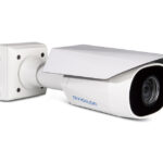 Eine moderne Überwachungskamera in Weiß mit schwarzer Linse, montiert auf einer Wandhalterung.