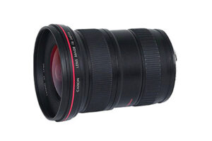 Eine schwarze Kameralinse von Canon mit rotem Ring und der Aufschrift „Lens Made in Japan“ auf der Seite.