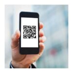 Ein Smartphone wird von einer Hand gehalten und zeigt einen QR-Code auf dem Bildschirm.