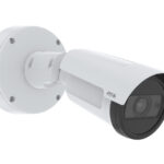 Eine weiße Überwachungskamera, die an einer Wandhalterung befestigt ist.