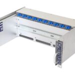 Ein silbernes elektronisches Gerät namens AMG MC203+ mit blauen Steckverbindern und Griffen auf beiden Seiten.