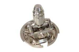Ein silbernes mechanisches Bauteil mit zylindrischen und kreisförmigen Elementen, möglicherweise Teil einer Maschine.