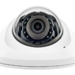 Eine weiße, kuppelförmige Überwachungskamera mit einer Linse in der Mitte.