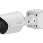 Eine weiße Sicherheitskamera der Marke Avigilon mit einem wetterfesten Gehäuse, montiert an einer Wandhalterung.