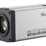 Ein silberner HD-SDI-Kamera-Block mit einem 30-fachen optischen Zoom und verschiedenen technischen Spezifikationen auf der Seite, darunter 60fps Full HD 1080p, EX-SDI-Unterstützung und WDR.