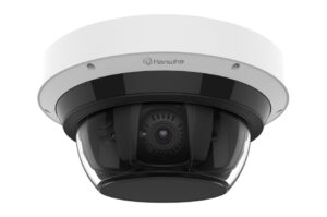 Eine Dome-Überwachungskamera mit der Aufschrift 'Hanwha', die eine schwarze Gehäuseabdeckung und eine transparente Kuppel hat, durch die das Objektiv sichtbar ist.