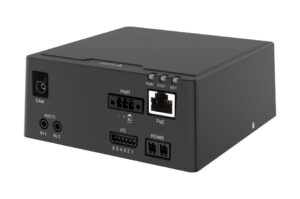 Ein schwarzes elektronisches Gerät mit verschiedenen Anschlüssen und Ports, darunter ein RJ45-Netzwerkanschluss, Audioeingänge, Stromanschlüsse und weitere spezialisierte Schnittstellen auf der Vorderseite.