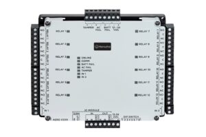 Eine IO-Modul-Platine von Hanwha, Modell AERO X300, mit 12 Relais, mehreren Anschlussklemmen und einem DIP-Schalter auf der Vorderseite. Die Statusanzeigen beinhalten Online, Kommunikation, Batteriefehler, Netzfehler und Sabotage. Die Moduleingänge sind links und rechts mit den Beschriftungen NO, C und NC versehen.