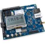 Elektronische Leiterplatte mit einem Display, auf dem "IRIS-4 by ADDSECURE" steht, umgeben von Anschlüssen und Schaltkreisen, einschließlich Ethernet- und Antennenanschlüssen.