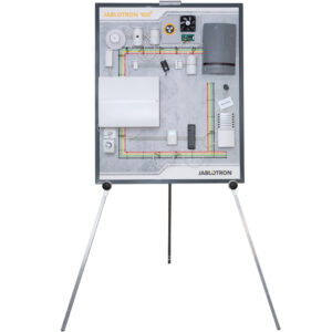 Eine Präsentationstafel auf einem Stativ zeigt ein Sicherheitssystem-Layout mit verschiedenen elektronischen Komponenten, verkabelten Sensoren und Steuergeräten, versehen mit dem Markennamen 'Jablotron 100'.
