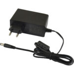 Ein schwarzes Netzteil mit Eurostecker, inklusive eines langen Kabels mit einem zylindrischen Stecker am Ende.