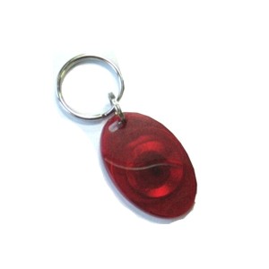 Roter ovaler Schlüsselanhänger aus transparentem Material an einem Metallring.