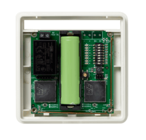Grünes elektronisches Bauteil mit einer vertikal montierten Batterie und mehreren Chips, auf einer grünen Platine in einem cremefarbenen Gehäuse platziert.