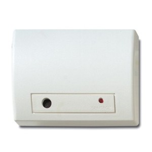 Weiße Sensorbox mit einem runden schwarzen Sensor und einer kleineren, roten LED-Anzeige auf der Vorderseite.