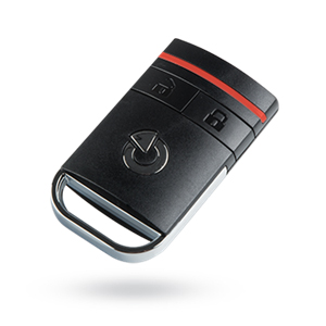 Eine schwarze Fernbedienung mit einem zentralen Knopf und roten Akzenten liegt schwebend auf weißem Hintergrund.